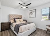 Thumbnail 6 of 26 - A bedroom with a large bed, a ceiling fan, and a window with blinds.