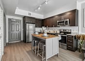 Thumbnail 3 of 34 - A modern kitchen with a wooden floor and white walls.