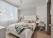 Thumbnail 11 of 34 - A bedroom with a white bed and a white chair.