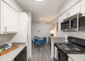 Thumbnail 4 of 27 - a kitchen with a stove and a microwave and a table with chairs