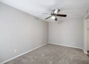 Thumbnail 14 of 27 - an empty room with a ceiling fan and a carpet