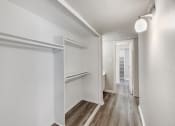 Thumbnail 15 of 27 - an empty room with white walls and wood floors and a hallway with a white door