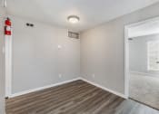 Thumbnail 18 of 27 - the living room of an apartment with wood flooring and a door to the bedroom