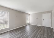 Thumbnail 11 of 27 - an empty living room with wood floors and a white door