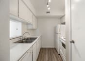 Thumbnail 12 of 27 - the preserve at ballantyne commons apartment kitchen with sink and white cabinets