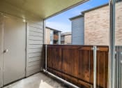 Thumbnail 21 of 27 - the entrance to a balcony with a wooden fence and a door to a brick building