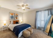 Thumbnail 6 of 20 - a bedroom with a large bed and a ceiling fan