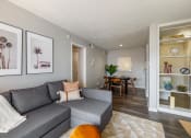 Thumbnail 2 of 20 - a living room with a gray couch and a dining room