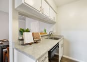 Thumbnail 5 of 20 - a kitchen with white cabinets and a counter top and a sink