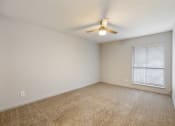 Thumbnail 15 of 20 - an empty living room with a ceiling fan and a window