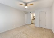Thumbnail 17 of 20 - a spacious living room with white walls and a ceiling fan