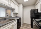 Thumbnail 13 of 20 - a kitchen with white cabinets and a sink and a refrigerator