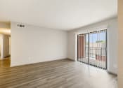 Thumbnail 10 of 20 - the spacious living room of an apartment with a balcony and wood flooring