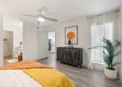 Thumbnail 19 of 37 - a bedroom with a bed and a dresser and a ceiling fan