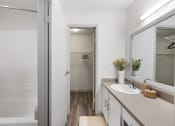 Thumbnail 22 of 37 - a bathroom with a shower and a sink and a mirror