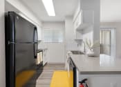 Thumbnail 3 of 37 - a kitchen with a black refrigerator and a white counter top
