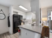 Thumbnail 2 of 37 - a kitchen with a black refrigerator and a white counter top