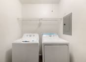 Thumbnail 25 of 37 - two washers and dryers in a laundry room with a door