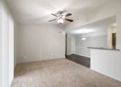 Thumbnail 5 of 37 - an empty living room with carpet and a ceiling fan