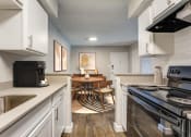 Thumbnail 1 of 20 - an open kitchen and dining room with white cabinets and appliances and a table and chairs