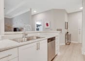 Thumbnail 10 of 17 - a large kitchen with white cabinets and a stainless steel sink
