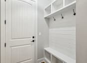 Thumbnail 15 of 38 - A white closet with a bench and hooks.