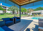 Thumbnail 15 of 20 - a covered patio with blue chairs and a pool