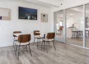 Thumbnail 15 of 29 - a dining room with a table and chairs and a tv on the wall