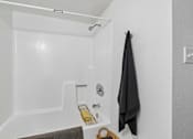 Thumbnail 8 of 26 - A bathroom with a black towel hanging on the wall.
