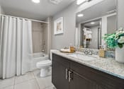Thumbnail 16 of 34 - A modern bathroom with a white toilet and a shower curtain.