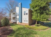 Thumbnail 1 of 14 - a blue and white apartment building with a tree in front of it