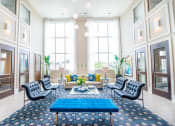 Thumbnail 4 of 33 - a living room with blue furniture and tall windows