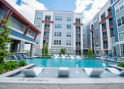 Thumbnail 13 of 33 - a swimming pool in front of an apartment building