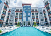 Thumbnail 12 of 33 - an apartment building with a large pool in front of it