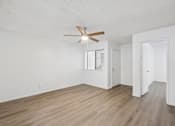 Thumbnail 12 of 26 - A room with a ceiling fan and wooden flooring.