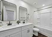 Thumbnail 52 of 56 - A white bathroom with a toilet, sink, and bathtub.