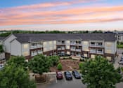 Thumbnail 17 of 17 - A large apartment complex with a parking lot in front.