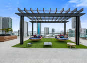 Thumbnail 5 of 66 - a rooftop lounge area with lounge chairs and a hammock with a view of the city