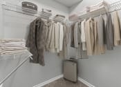 Thumbnail 10 of 32 - a closet with a rack of clothes and a suitcase