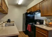 Thumbnail 1 of 8 - a kitchen with a sink and a black refrigerator