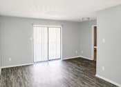 Thumbnail 12 of 19 - A room with a window covered by blinds and a wooden floor.