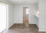 Thumbnail 11 of 19 - A room with wooden flooring and a window with blinds.