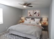 Thumbnail 1 of 19 - A bedroom with a bed, two lamps, and a ceiling fan.