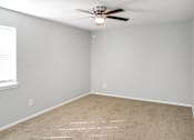 Thumbnail 3 of 19 - A room with a ceiling fan and carpeted floor.