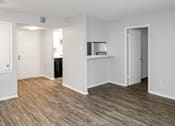 Thumbnail 15 of 19 - A room with white walls and wood flooring with a door on the left and a shelf on the right.