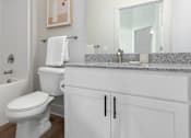 Thumbnail 11 of 11 - A white toilet sits next to a sink in a bathroom.