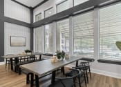 Thumbnail 20 of 32 - a dining room with large windows and a table with chairs