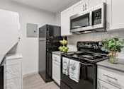Thumbnail 17 of 38 - A kitchen with black appliances and white cabinets.