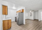 Thumbnail 10 of 26 - A kitchen with a refrigerator, sink, and wooden cabinets.