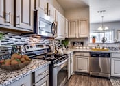 Thumbnail 4 of 39 - a kitchen with stainless steel appliances and marble counter tops